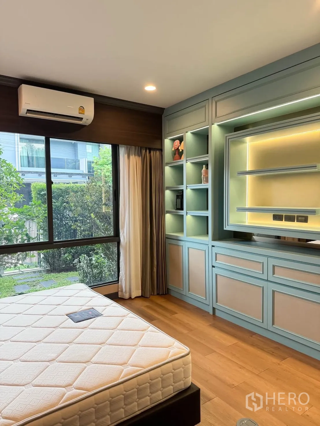 บ้านเดี่ยว for rent in Bang Kapi, Bangkok - ห้องนอนมีหน้าต่างบานใหญ่ ตู้และชั้นบิลท์อินสีเขียวมิ้นต์ มองสู่สวน