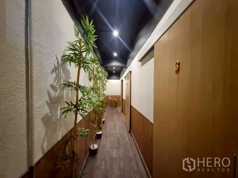 店屋 出租或出售在Watthana, Bangkok - 走廊通往包间，摆放竹子绿植。