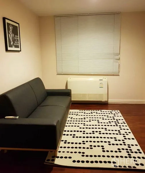 Detached House for rent in Bang Phli, Samut Prakan - Compact study or guest room with a black sofa, patterned rug and wall air-conditioner.