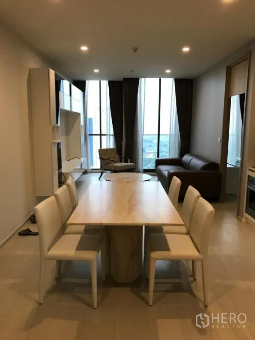 Condominium for rent or sale in Pathum Wan, Bangkok - Dining table for six facing tall windows with city skyline views from the high floor.