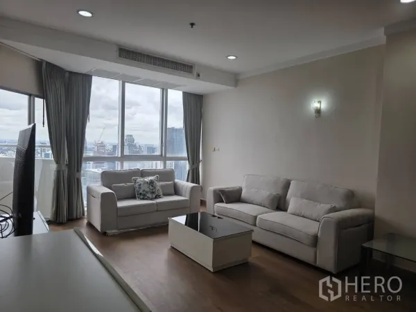 คอนโด ให้เช่าในKhlong Toei, Bangkok - ห้องนั่งเล่นสว่างพร้อมโซฟาสีเทา โต๊ะกลาง และหน้าต่างบานใหญ่ชมวิวกรุงเทพฯ