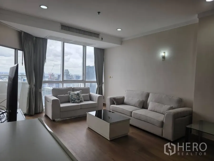 คอนโด ให้เช่าในKhlong Toei, Bangkok - ห้องนั่งเล่นสว่างพร้อมโซฟาสีเทา โต๊ะกลาง และหน้าต่างบานใหญ่ชมวิวกรุงเทพฯ