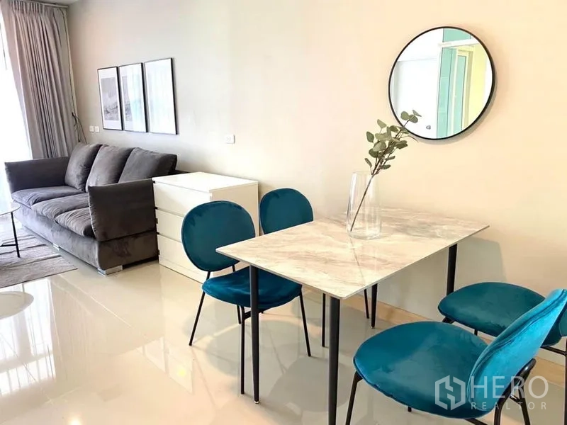 Townhouse for rent in Bang Phli, Samut Prakan - Dining nook with marble-top table, four teal chairs and round wall mirror.
