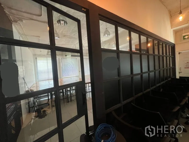 办公空间 出租在Khlong Toei, Bangkok - 走廊一侧为黑框玻璃墙，通往内部的会议/办公区域。