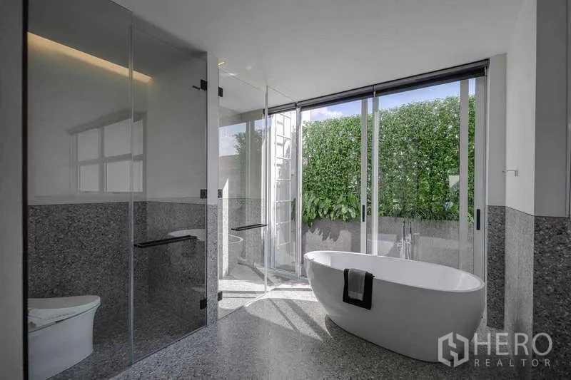 Home Office for rent in Bang Phli, Samut Prakan - Luxury bathroom with freestanding tub, glass shower and doors to a hedge-lined terrace.