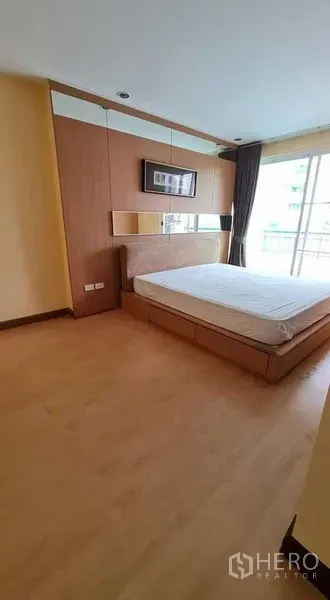 คอนโด ให้เช่าในWatthana, Bangkok - ห้องนอนใหญ่โทนไม้ หน้าต่างบานใหญ่ ทางออกระเบียง และหัวเตียงบิลท์อิน