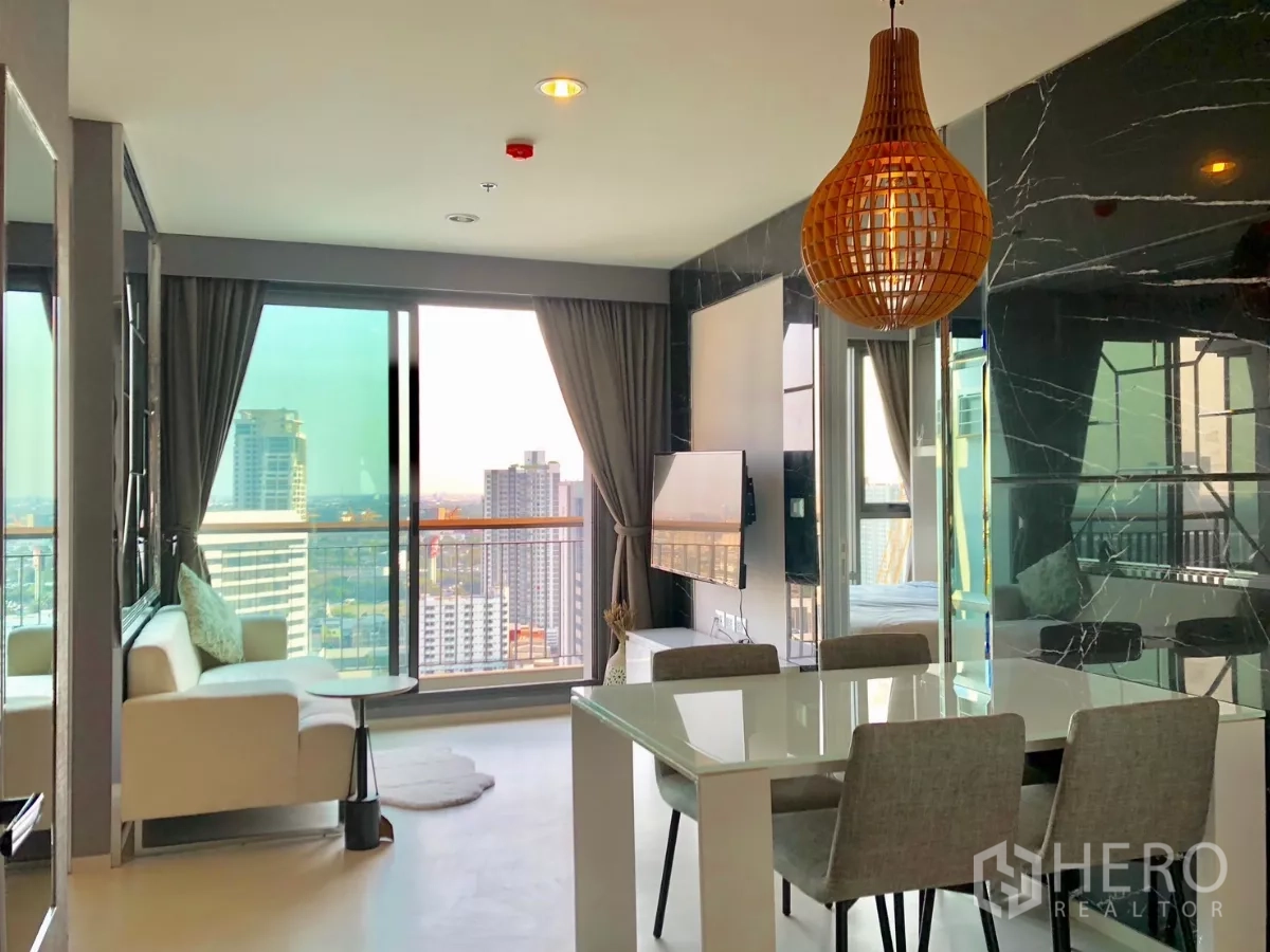 Condominium for rent in Khlong Toei, Bangkok - Bright living and dining area with large balcony doors and city view.