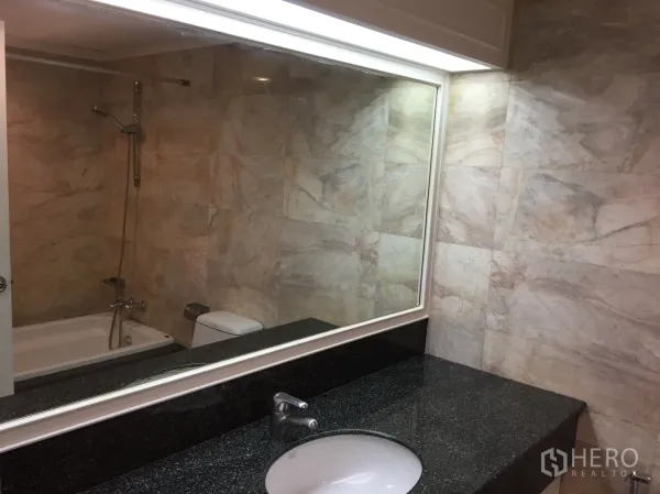 คอนโด ให้เช่าในKhlong Toei, Bangkok - ห้องน้ำปูกระเบื้องลายหินอ่อน อ่างอาบน้ำพร้อมฝักบัว และเคาน์เตอร์หินแกรนิตยาวกระจกบานใหญ่