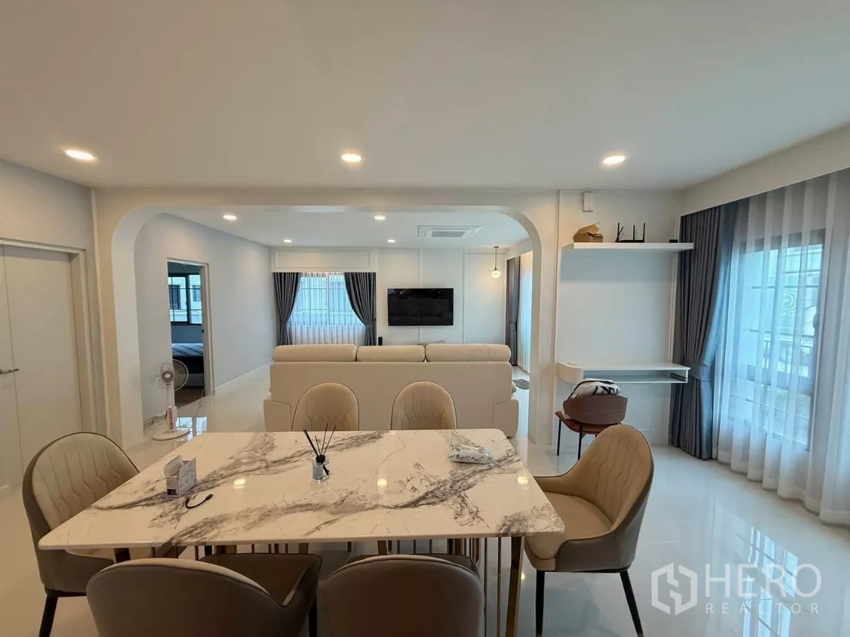 Detached House for rent in Bang Phli, Samut Prakan - Bright open-plan dining and living area with marble table, upholstered chairs and large windows.