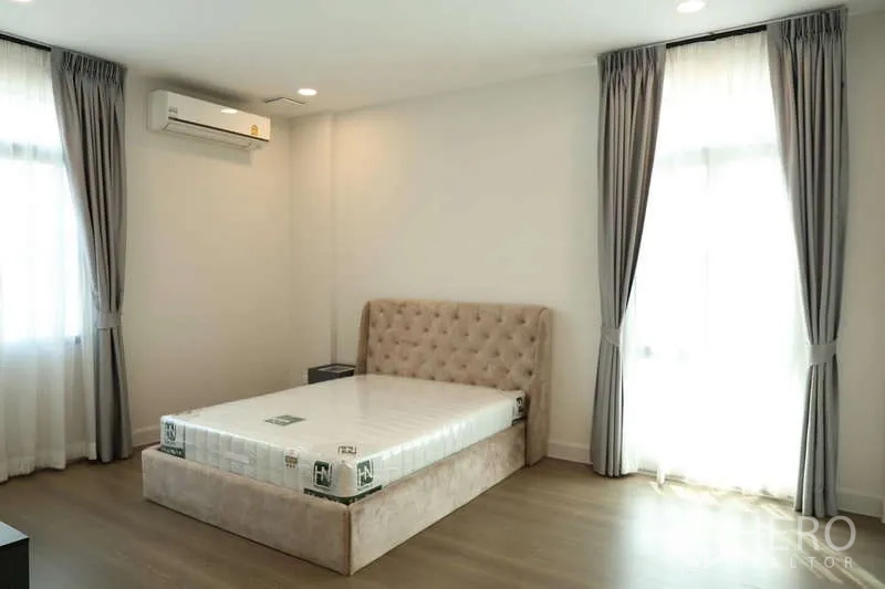 独立式住宅 出租或出售在Saphan Sung, Bangkok - 采光充足的卧室，软包床、木地板与双层窗帘