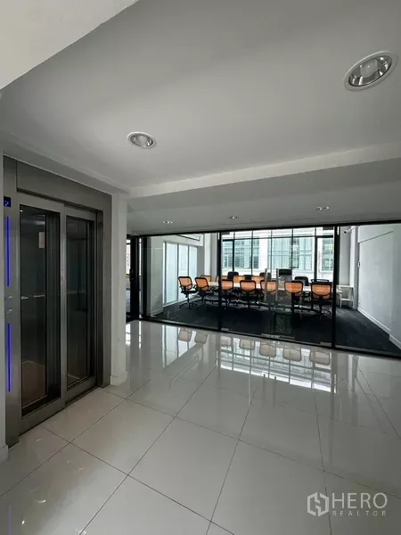 Home Office for rent - Elevator lobby with glossy tiles facing a glass-walled meeting room.
