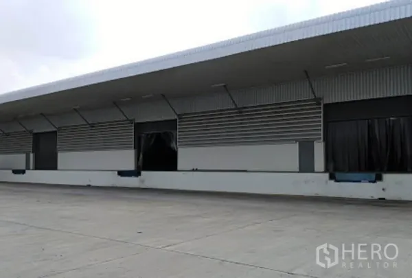 货栈 出租在Phra Nakhon Si Ayutthaya - 带雨棚的装卸月台，多个装卸口与月台调节板，前方为宽阔硬化场地。