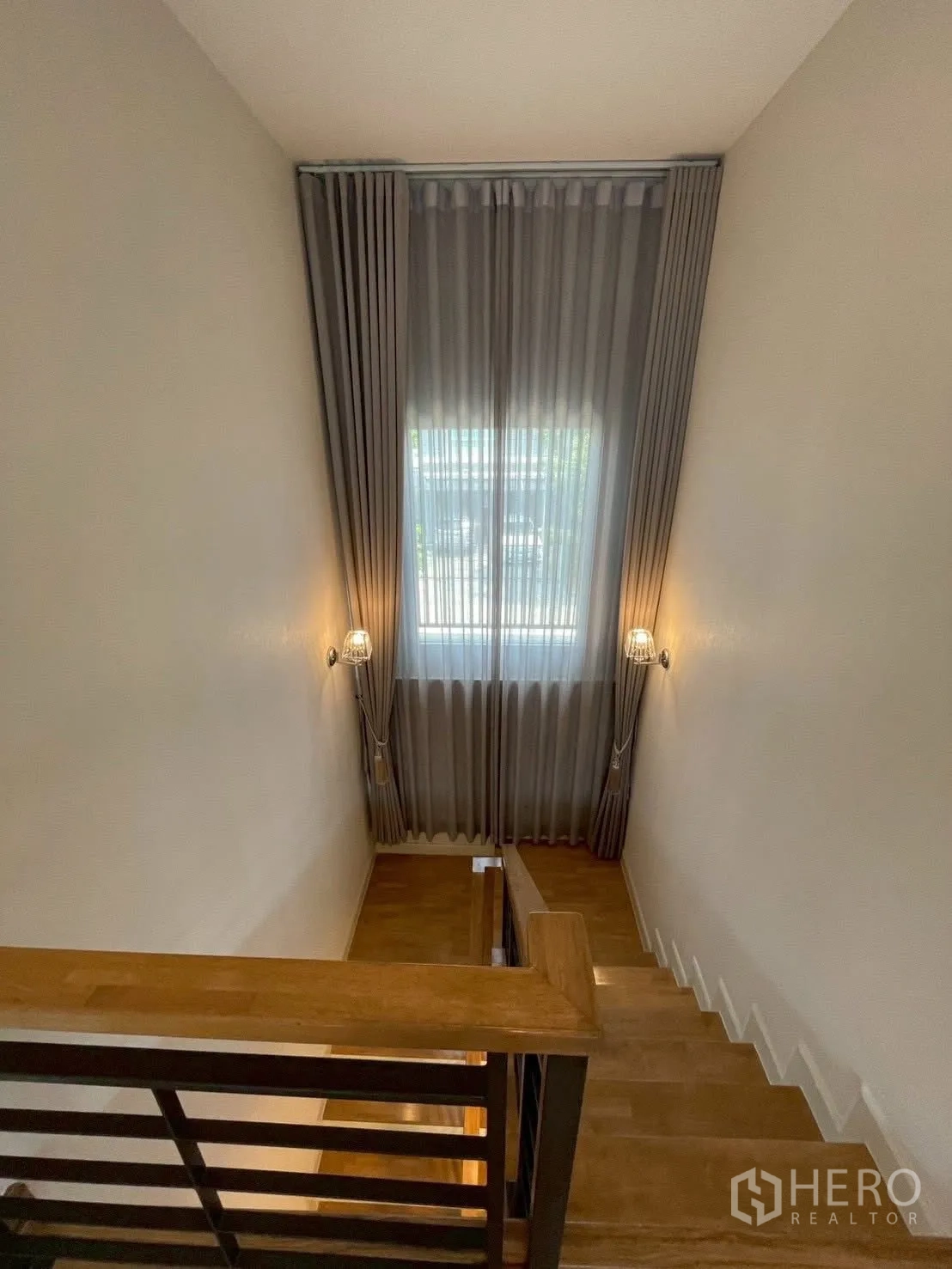 Detached House for rent in Prawet, Bangkok - Staircase landing with tall window, full-length curtains and wall sconces.