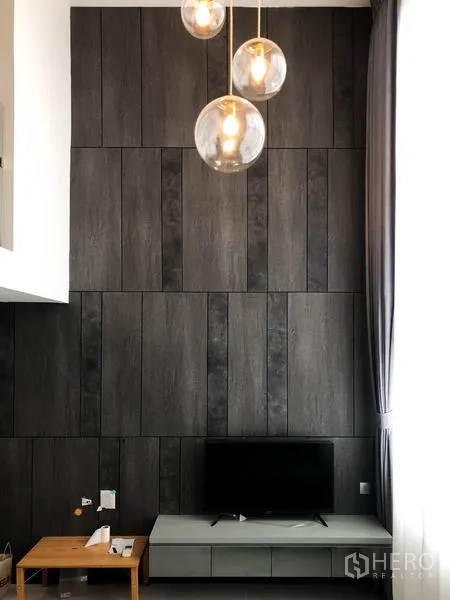 公寓 出租在Sathon, Bangkok - 电视背景墙，低矮电视柜、深色木饰面与球形吊灯、纱帘。