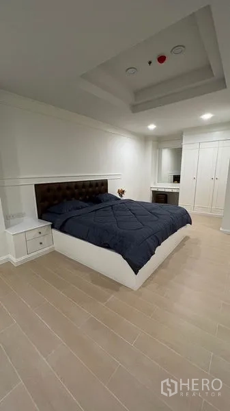 公寓 出租在Watthana, Bangkok - 瓦他那区宽敞卧室，软包床头、吊顶灯、内置衣柜与木纹地板的公寓。