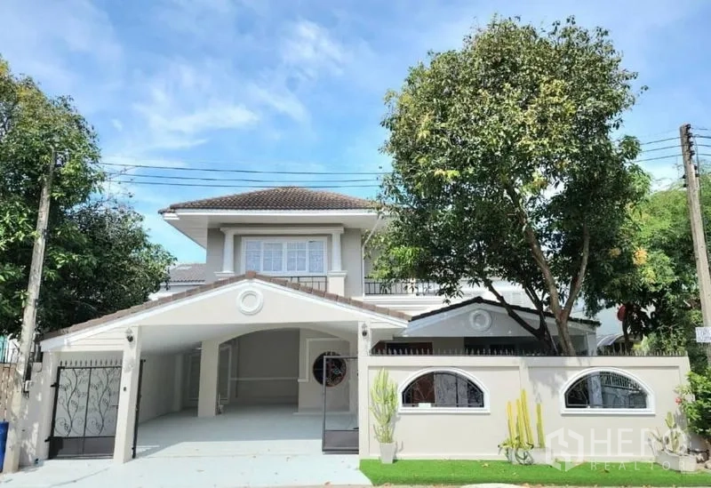 บ้าน ให้เช่าในLam Luk Ka, Pathum Thani - ด้านหน้าบ้านเดี่ยวสองชั้น พร้อมประตูรั้วและต้นไม้ใหญ่