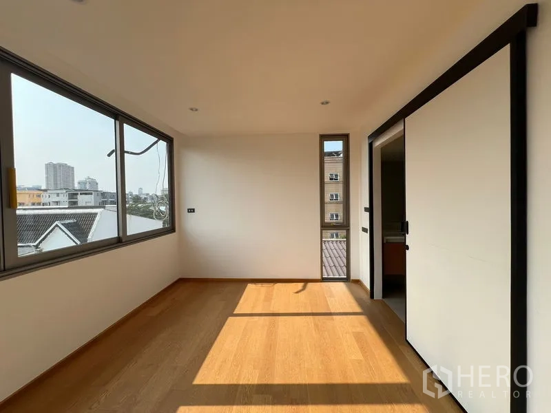 สำนักงานที่บ้าน ให้เช่าหรือขายในChatuchak, Bangkok - ห้องนอนสว่างพร้อมประตูบานเลื่อนเข้าสู่ห้องน้ำและหน้าต่างสองด้าน