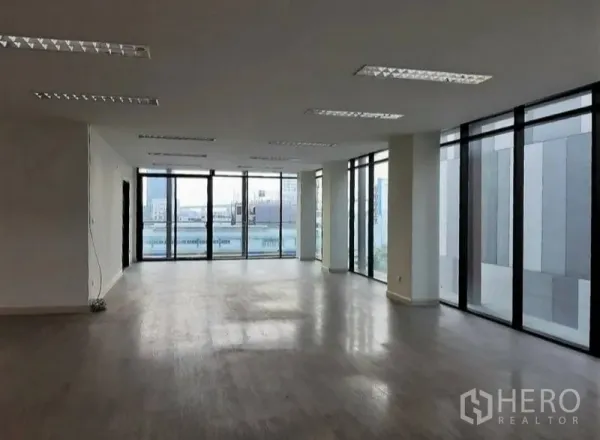 Office Space for rent in Bang Kho Laem, Bangkok - Open-plan office with floor-to-ceiling windows, wood-look floors and a wide city outlook.