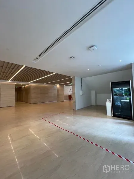 零售空间 出租 - 现代化大堂，浅色石材地面与木格天花，展示小型零售铺位