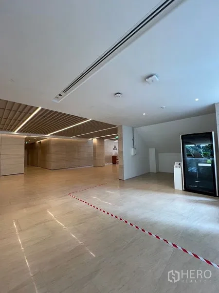 零售空间 出租 - 现代化大堂，浅色石材地面与木格天花，展示小型零售铺位