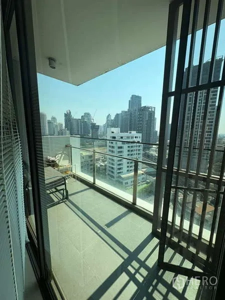 Condominium for rent - Private balcony with glass railing overlooking the Thonglor skyline.