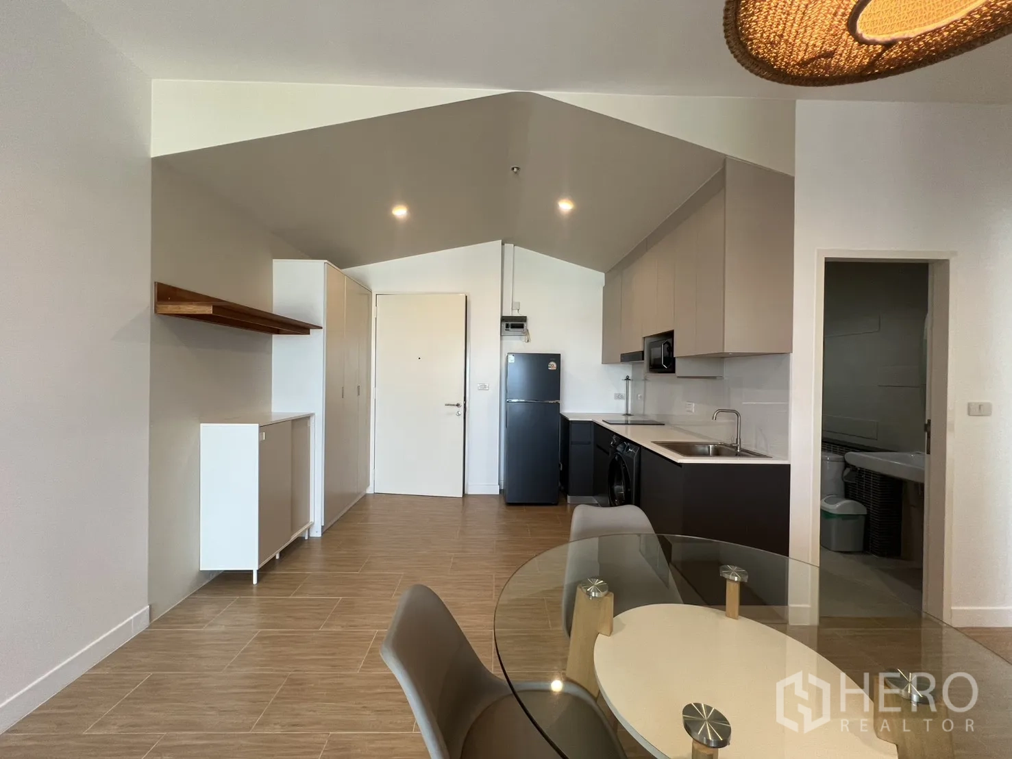 Condominium for rent in Bang Kapi, Bangkok - Wide view of the entry and kitchen with ample overhead cabinetry.