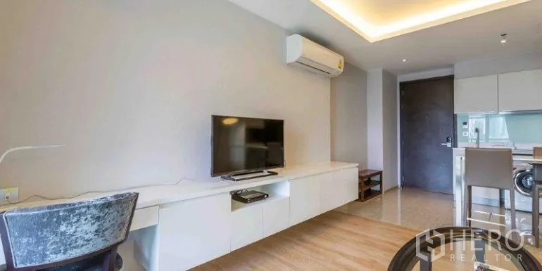 คอนโด ให้เช่าหรือขายในWatthana, Bangkok - พื้นที่นั่งเล่นมีชั้นวางทีวียาว เครื่องปรับอากาศติดผนัง และโต๊ะทำงาน