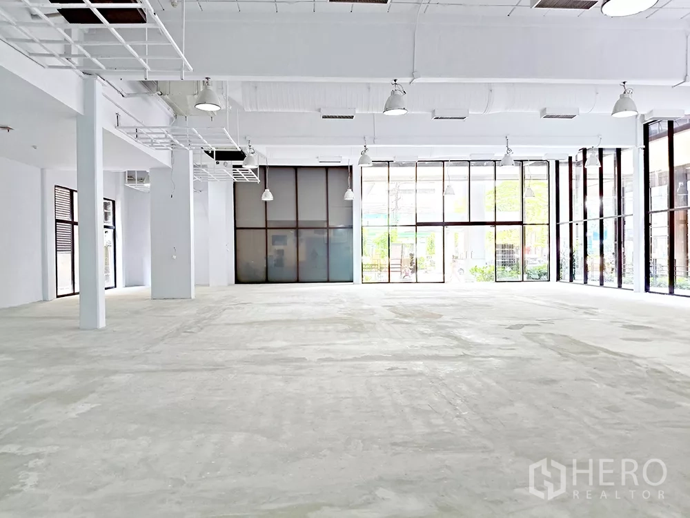 Office Space for rent in Watthana, Bangkok - Open office space with high ceiling, pendant lights, and wide glass frontage to the courtyard.