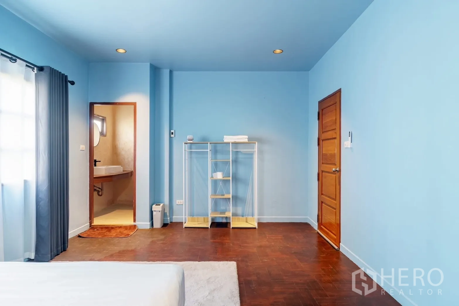 联排别墅 for rent in Watthana, Bangkok - 蓝色卧室，带套内门、开放置物架与木地板。