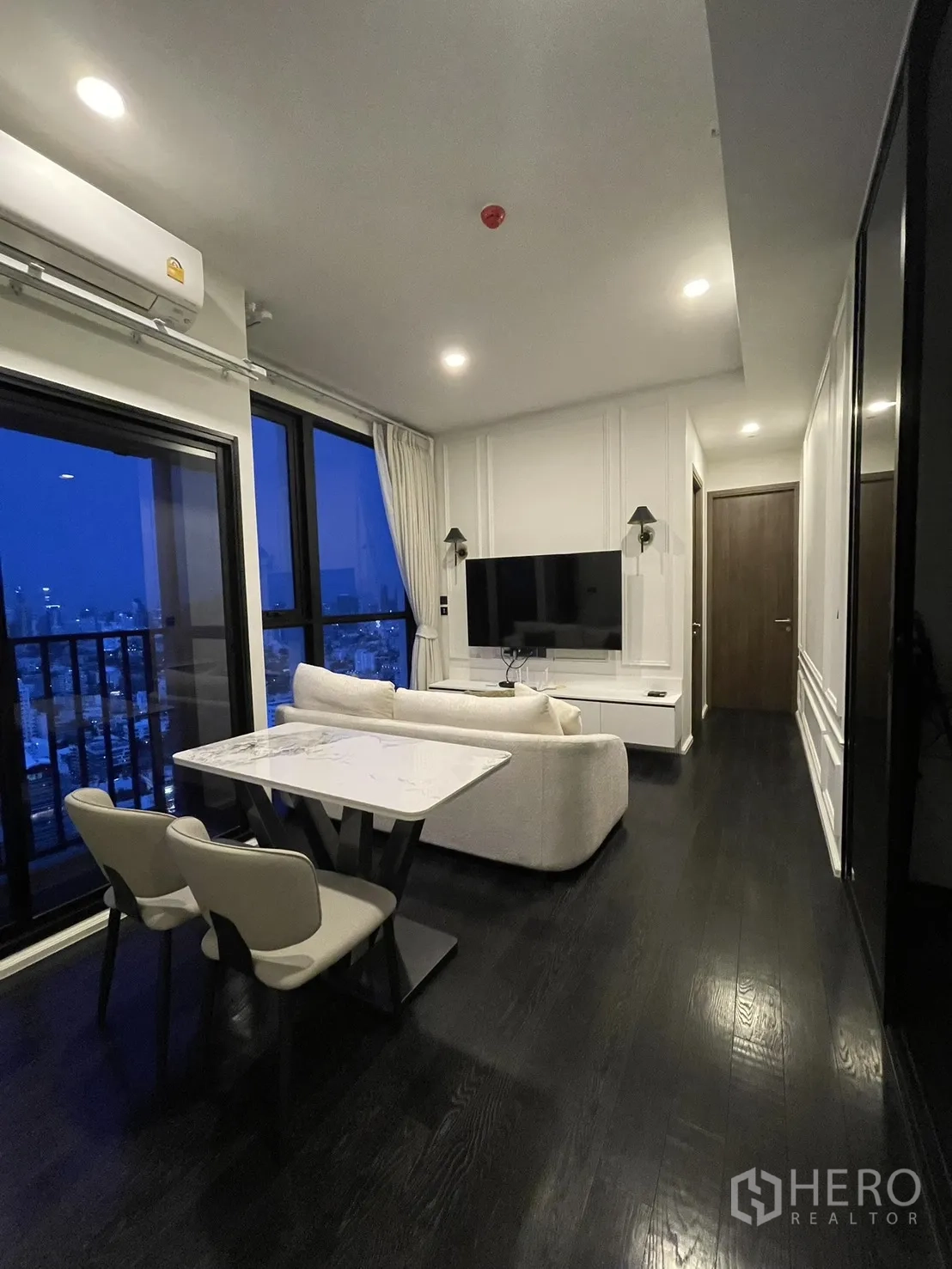 Condominium for rent in Watthana, Bangkok - Open-plan dining and living area with balcony and night city view.