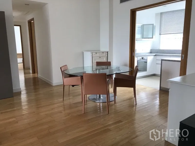 คอนโด ให้เช่าในKhlong Toei, Bangkok - มุมรับประทานอาหารโต๊ะกระจกทรงกลม ถัดไปเป็นครัวปิดสว่างพร้อมประตูบานเลื่อน