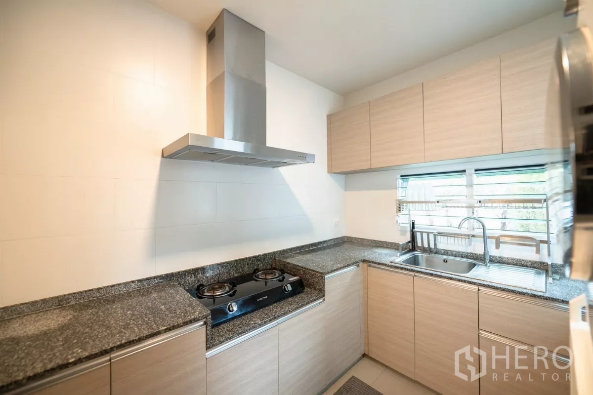 Detached House for rent or sale in Prawet, Bangkok - Separate Thai kitchen with gas hob, range hood and granite countertops.