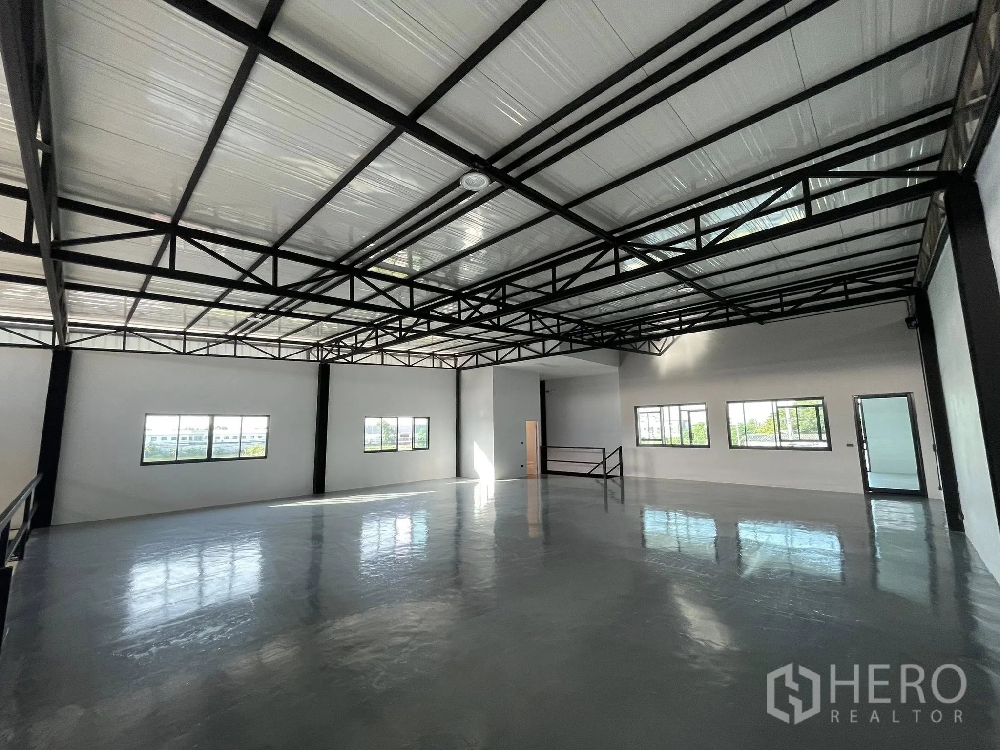 Warehouse for rent in Phra Samut Chedi, Samut Prakan - Wide clear-span production space with glossy floor and stair access.