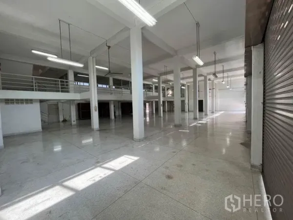 店屋 出租在Khlong Toei, Bangkok - 宽敞的商铺式楼房室内，大开间结构，高柱与夹层走道，明亮灯光及卷帘门。