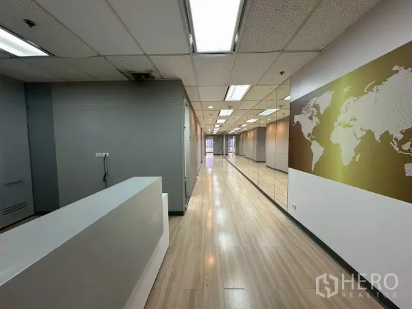 Office Space for rent in Watthana, Bangkok - Reception desk and long corridor with mirrored wall and world map graphic in a fitted office.