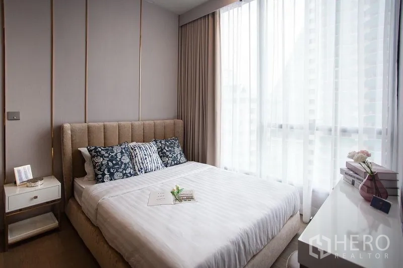 คอนโด ให้เช่าในWatthana, Bangkok - ห้องนอนสว่างด้วยเตียงหัวบุผ้า โต๊ะข้าง และหน้าต่างบานใหญ่พร้อมม่านโปร่ง