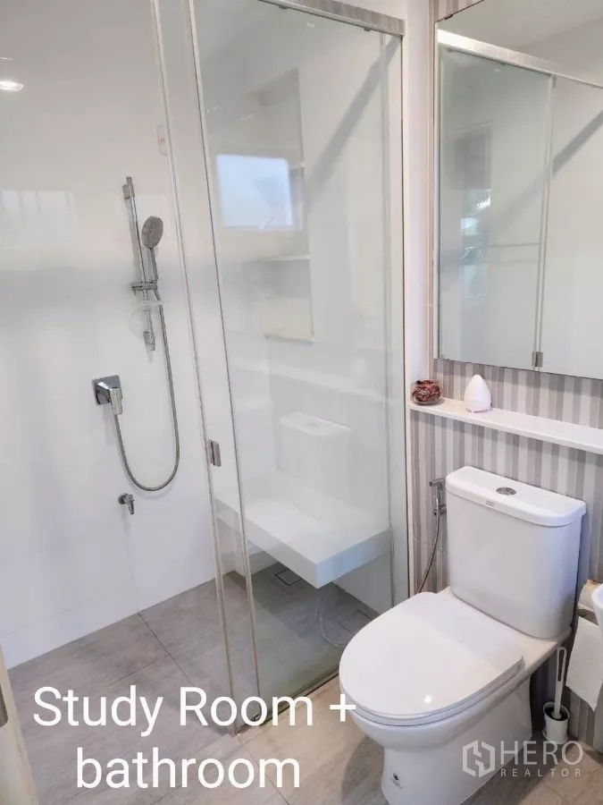 Detached House for rent in Samut Prakan - Contemporary bathroom with glass shower enclosure, handheld shower, mirror cabinet, and toilet.
