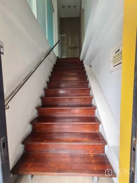 零售空间 出租在Watthana, Bangkok - 入户木楼梯，金属扶手向上延伸。