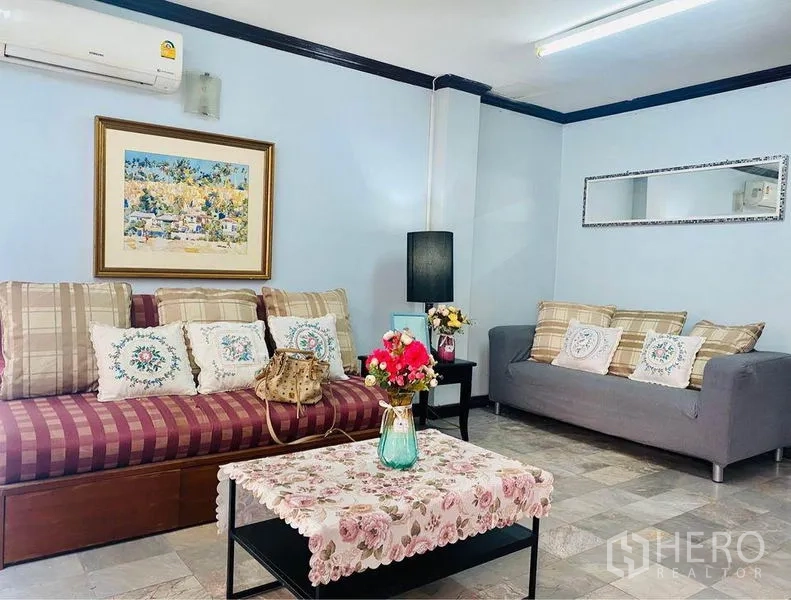 ทาวน์เฮาส์ ให้เช่าหรือขายในPrawet, Bangkok - มุมนั่งเล่นอบอุ่น โซฟา แอร์ แขวนภาพ และโต๊ะกลางลายดอก