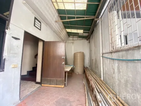 零售空间 出租在Watthana, Bangkok - 后勤区有顶棚与瓷砖地面，木门与管材存放区