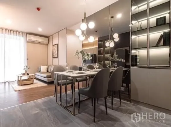 Condominium for rent in Watthana, Bangkok - Open-plan living and dining area with marble table, pendant lights, and mirrored wall.