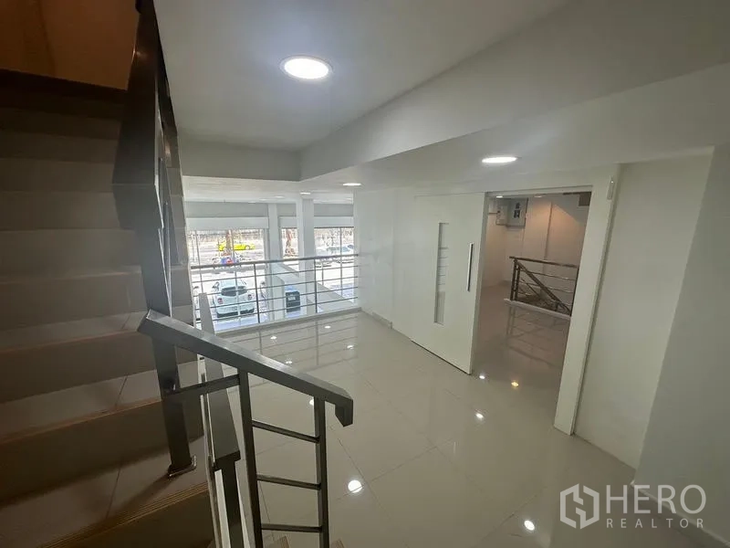 带办公室的家 出租在Bang Na, Bangkok - 夹层走廊，金属栏杆，俯瞰前方落地玻璃与街景。