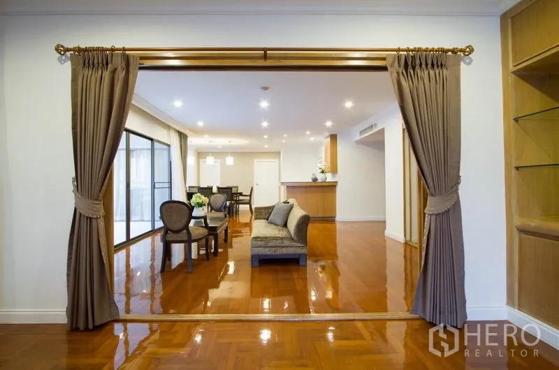 คอนโด ให้เช่าในWatthana, Bangkok - มุมมองกว้างของห้องนั่งเล่นและรับประทานอาหาร มีผ้าม่าน ไฟดาวน์ไลท์ และพื้นไม้เงา