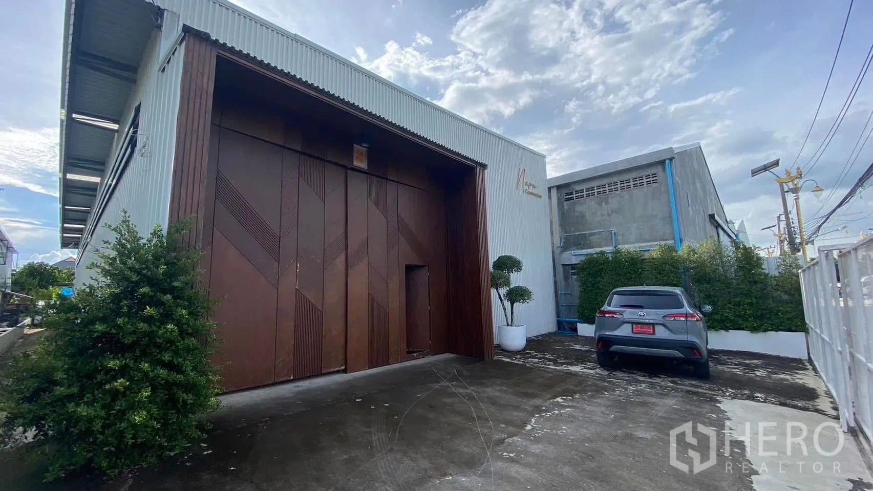 โกดัง for rent in Mueang Samut Prakan, Samut Prakan - ด้านหน้าโกดังพร้อมประตูบานเลื่อนขนาดใหญ่และที่จอดรถ