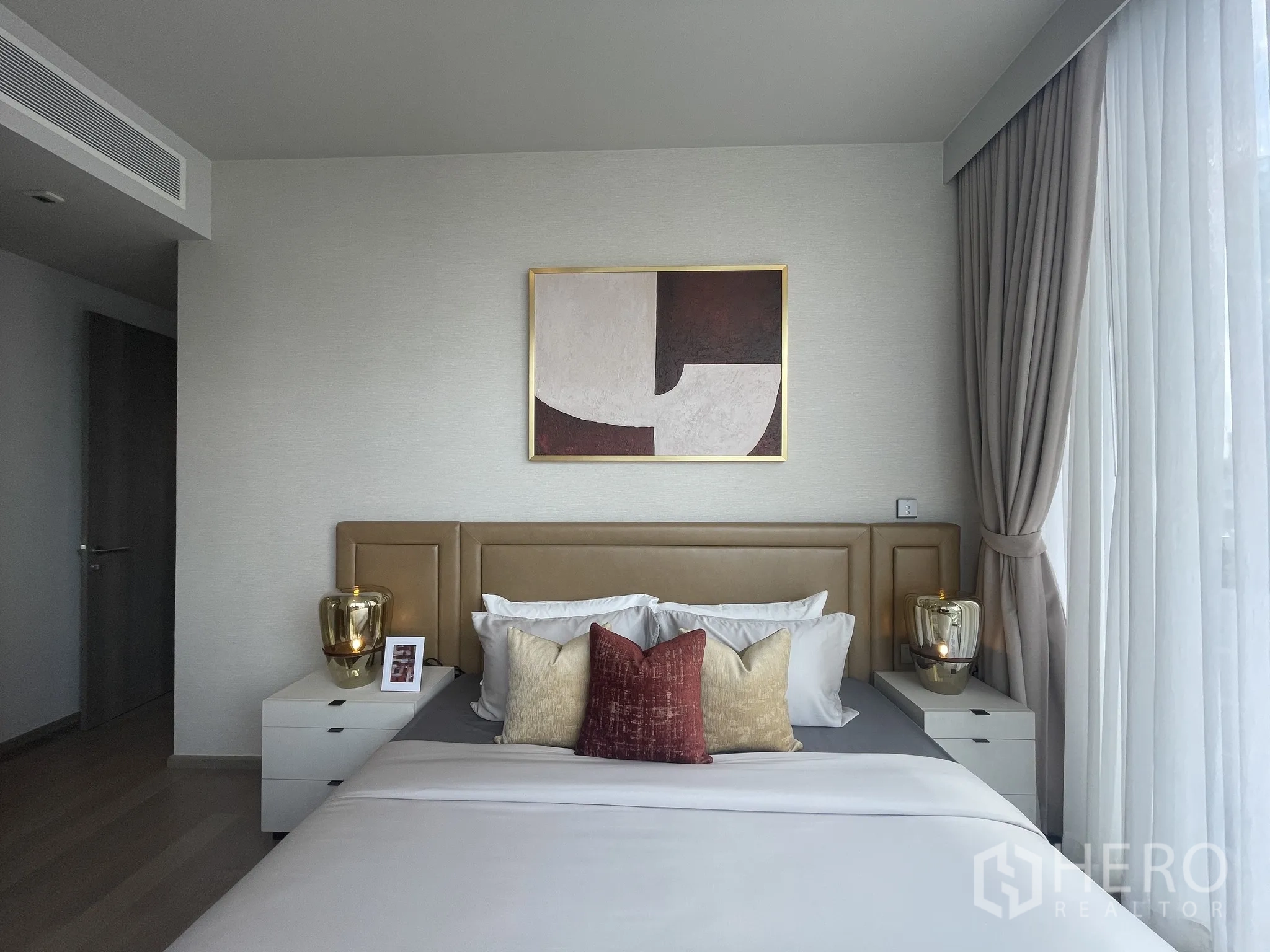 Condominium for rent in Watthana, Bangkok - Bright bedroom with upholstered headboard, bedside tables, and wall art.