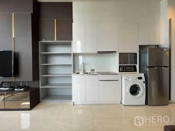 Condominium for rent in Bang Rak, Bangkok - Modern white kitchenette with built-in cabinets, sink, microwave, fridge and washing machine.