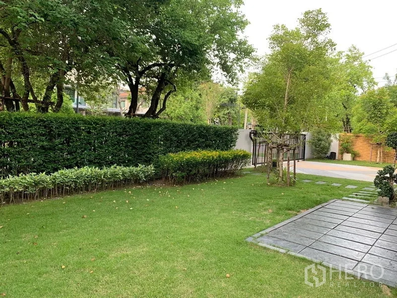 Detached House for rent or sale in Bang Phli, Samut Prakan - Private lawn garden with hedges, trees and a paved walkway.