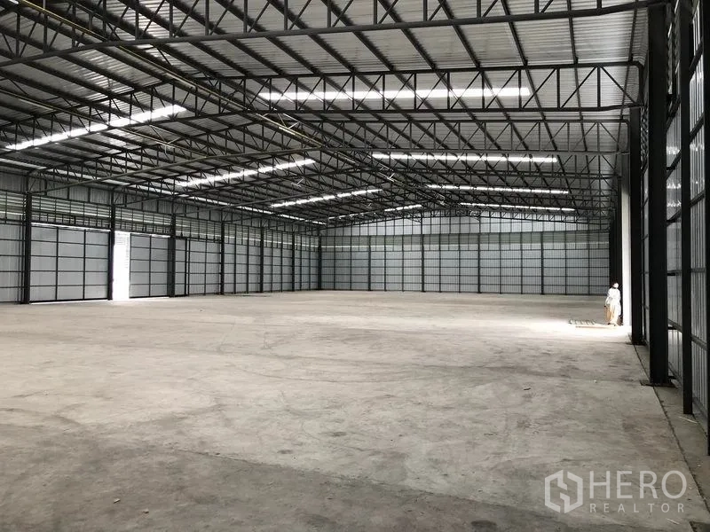Warehouse for rent in Pathum Thani - Open-plan warehouse interior with skylights and large doors providing abundant light and easy access.