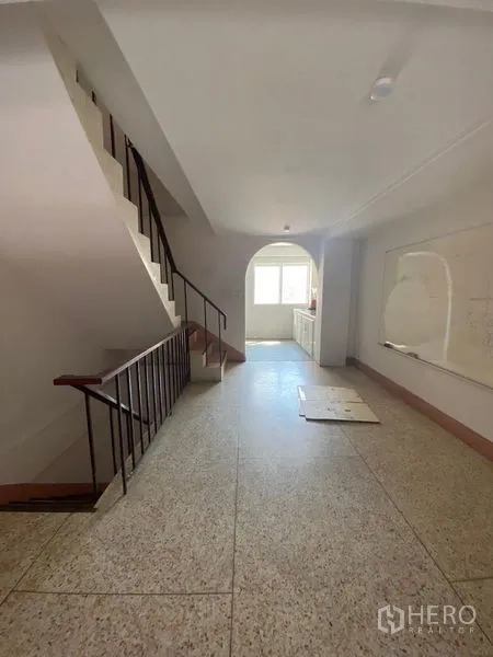 店屋 出租或出售在Suan Luang, Bangkok - 楼层过道铺水磨石地面，带楼梯与拱形门洞。