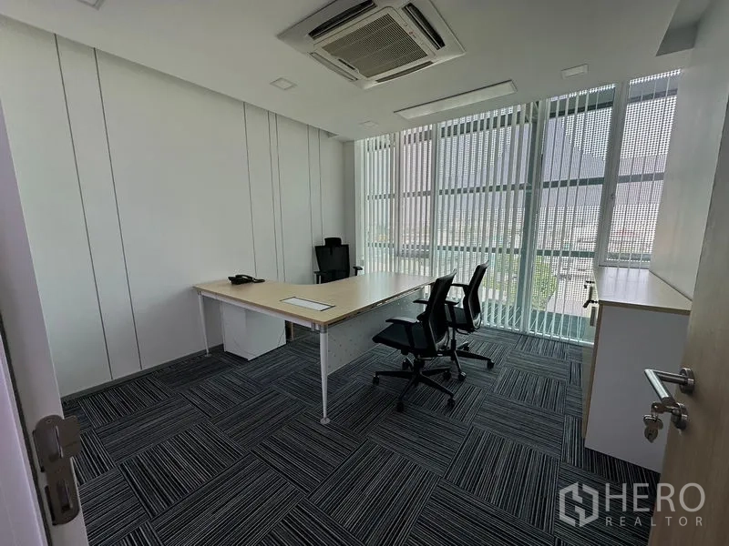 Office Space for rent - Glass-walled manager room with modern carpet, desk and seating beside tall windows.